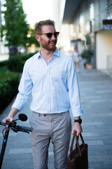Young stylish businessman with e-scooter. Portrait of handsome man outdoors