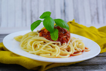 Delicious Italian spaghetti with tomato sauce and fresh basil, healthy cooked pasta for dinner and lunch in a gourmet restaurant.
