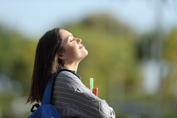 Happy student breathing fresh air in a campus