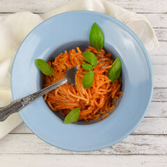 Delicious Italian spaghetti with tomato sauce and fresh basil, healthy cooked pasta for dinner and lunch in a gourmet restaurant.
