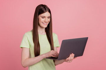 Photo of young attractive girl happy positvie smile look read browse laptop isolated over pink pastel color background