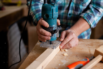  A carpenter in a plaid shirt works a workshop. Wood. Ecological compatibility. Lifestyle. Close up
