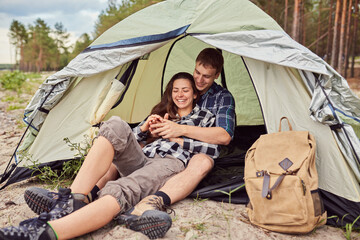 Couple camping. Young people sitting in tent