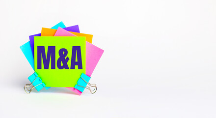 There are bright multi-colored stickers with the text M AND A. Copy space