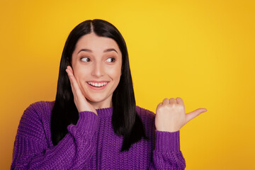 Portrait of young girl amazed shocked happy smile look indicate thumb empty space ad select...