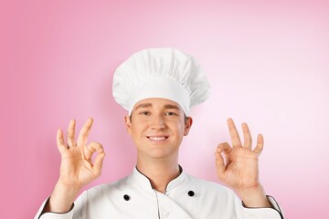 Cute young man cook posing in white uniform