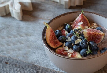 Healthy breakfast bowl with figs, blueberries, porridge, and  chocolate whey protein