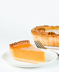 one sliced slice of pumpkin pie on a plate; front view