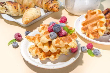 Modern dessert croffle - mixture of croissants and waffles, puff baking waffle iron pan, with berry, fruit cocolate topping