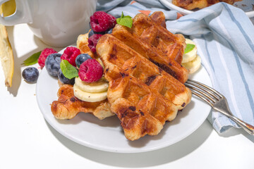 Modern dessert croffle - mixture of croissants and waffles, puff baking waffle iron pan, with berry, fruit cocolate topping
