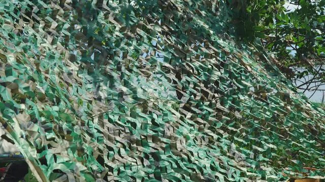 Military green camouflage net masking and covering a secret object
