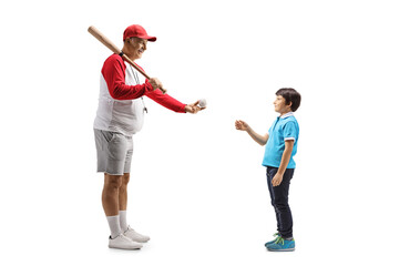 Full length profile shot of a mature man with a baseball bat giving a ball to a boy