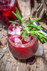 Cold autumn winter hibiscus cocktail with rosemary and crushed ice, copy space