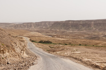 Fototapeta na wymiar Road through hills and cliffs in the Judean Desert in Israel