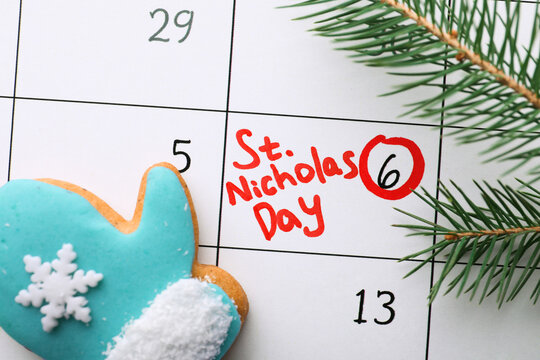 Gingerbread cookie and fir tree branch on calendar page with marked date, top view. December, 6 - Saint Nicholas Day