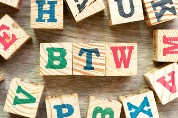Alphabet letter block in word BTW (Abbreviation of by the way) with another on wood background