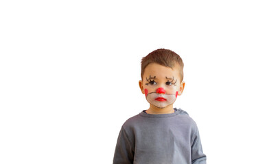 Sad child with the painted face of a clown