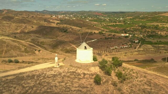 Old historical deserted windmill in Silves, Algarve, Portugal, aerial photo of the original traditional architecture in Iberian peninsula, mill on the hill above Silves, agriculture and countryside.