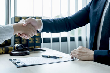 Handshake after Lawyer  providing legal consult business dispute service to the man at the office with justice scale and gavel hammer