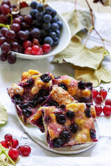Traditional Italian yeast dough pie with grapes Schiacciata and bunches of grapes on a light background.