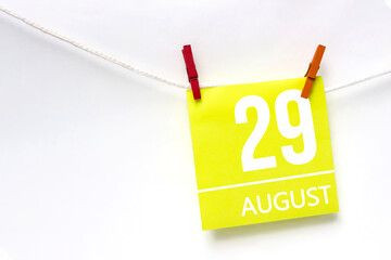 August 29th. Day 29 of month, Calendar date. Paper cards with calendar day hanging rope with clothespins on white background. Summer month, day of the year concept.