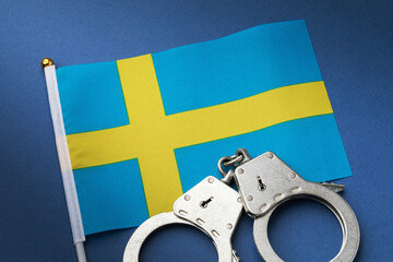 Sweden flag and handcuffs on blue background, country crime concept