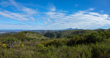 Green hills and blue mountains with thin white clouds