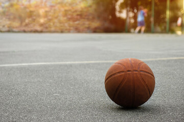 Basketball ball on the outdoor sports field on a sunny day.