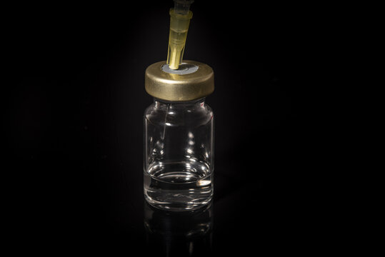 Syringe draws vaccine from ampoule. Coronavirus and flu cure. Close-up view.