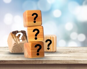 Cube with question mark on wooden desk