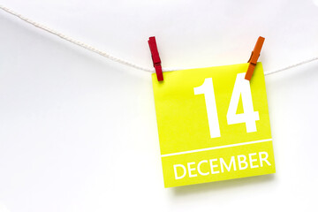 December 14th. Day 14 of month, Calendar date. Paper cards with calendar day hanging rope with clothespins on white background. Winter month, day of the year concept.