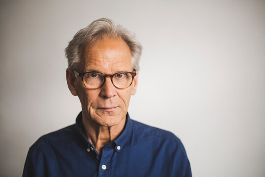 Portrait of senior man against wall