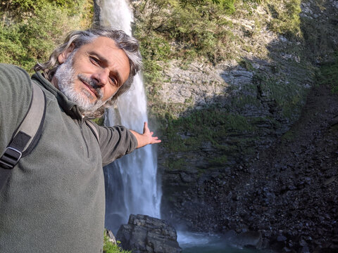 Closeup shot of a Caucasian male hiker making a selfie on the hill