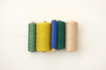 Set of cord in shades of green, retro .thread on spool on white background, flat lay. Equipment to creative DIY hobby hand works like embroidery. Colourful string, yarn on the roll.