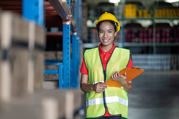 African American woman worker using clipboard working with products or parcel goods on shelf pallet in industrial storage warehouse