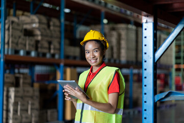 African American woman worker using clipboard working with products or parcel goods on shelf pallet in industrial storage warehouse