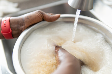 African American Nigerian woman washing rice before cooking