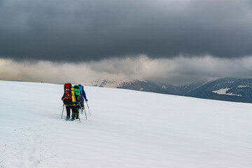 Fototapeta na wymiar Group of hikers explore the snow desert high in the mountains.