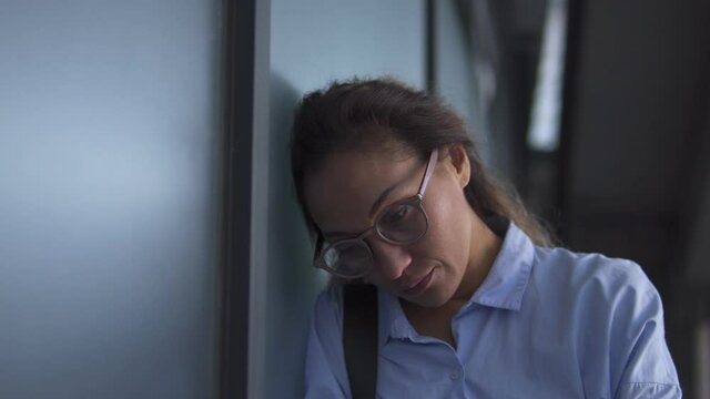 Deeply upset frustrated african american woman in eyeglasses leaning head on wall and crying, feeling lonely and sad, sexual harassment or abuse, work dismissal, problems with colleagues