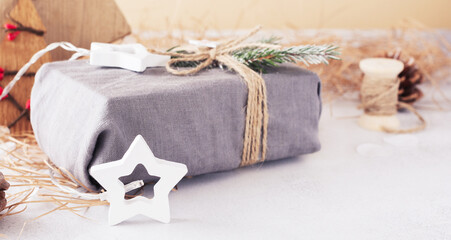 Fototapeta na wymiar Christmas or New Year concept. Garland light star and fabric wrapped gifts. Zero waste concept