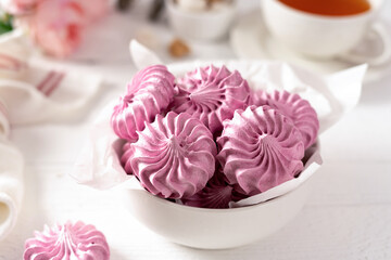 Italian and French meringue in a white plate on a light culinary background.