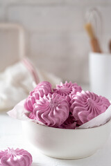 Italian and French meringue in a white plate on a light culinary background.