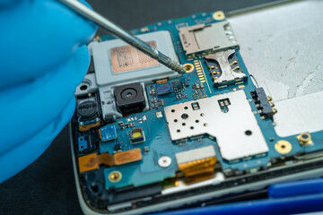 Technician repairing inside of mobile phone by soldering iron. Integrated Circuit. the concept of...