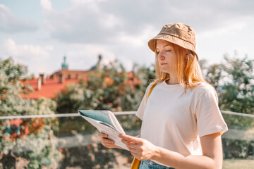 Fototapeta premium Happy young woman with a city map, traveling in Europe. Tourism, destination concept outdoors