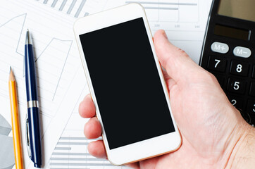 A smartphone with an empty screen in a man's hand. Copy space. The concept of mobile apps for business