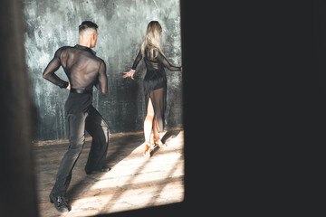 Couple of two professional ballroom dancers is dancing on loft studio. Beautiful art performance. Sport life concept. Passion and emotional dance.