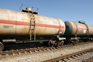 Fototapeta na wymiar Freight cars and tanks with liquid on the railway on the background of the railway at the station
