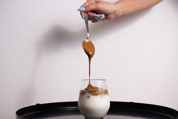 Coffee cream pouring in a glass of milk