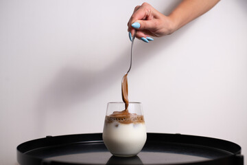 Coffee cream pouring in a glass of milk