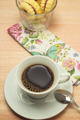 Uma xícara com café e porção de biscoitos amanteigados.